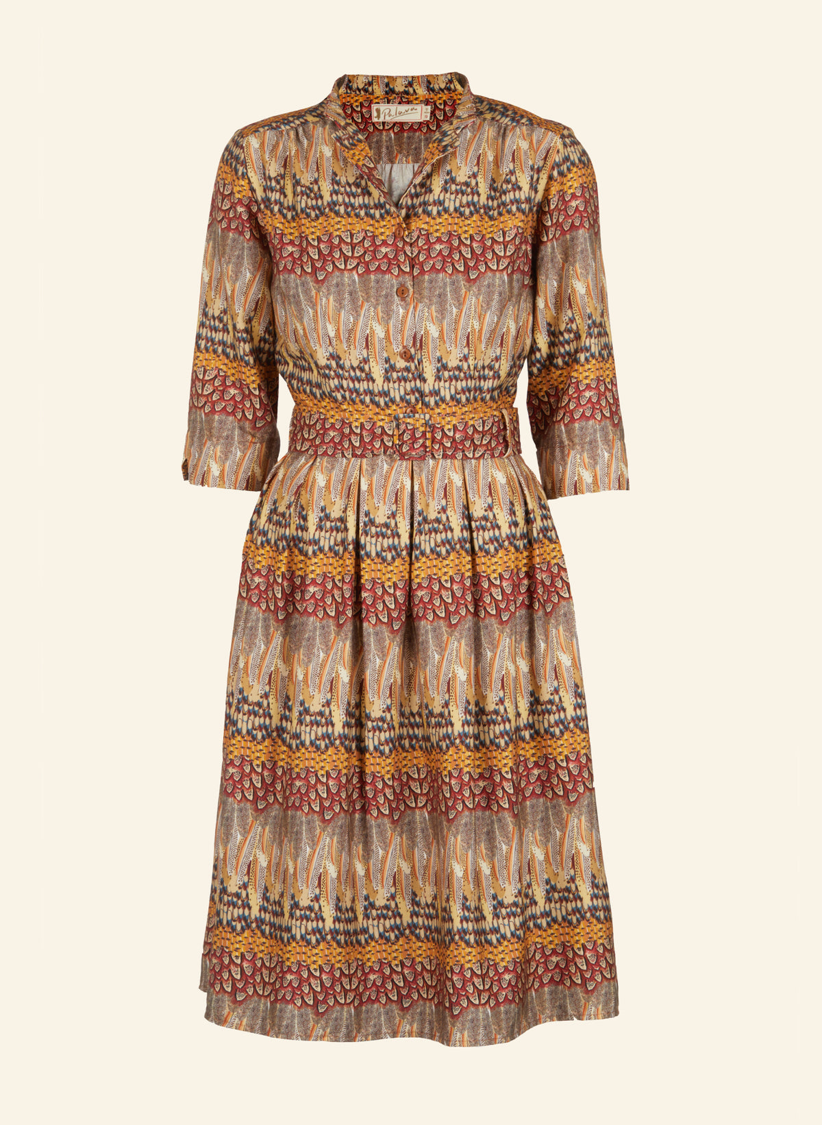 A long-sleeve midi dress with a patterned feather print in beige, rust red, and yellow, featuring a button-up front, collar, and matching waist belt.