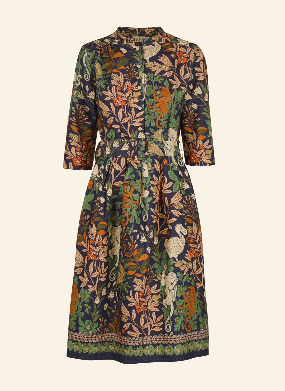 A three-quarter sleeve midi dress with a multicolor botanical and animal print on a dark navy base, featuring a button-up front and a decorative border at the hem, shown against a solid off-white background.