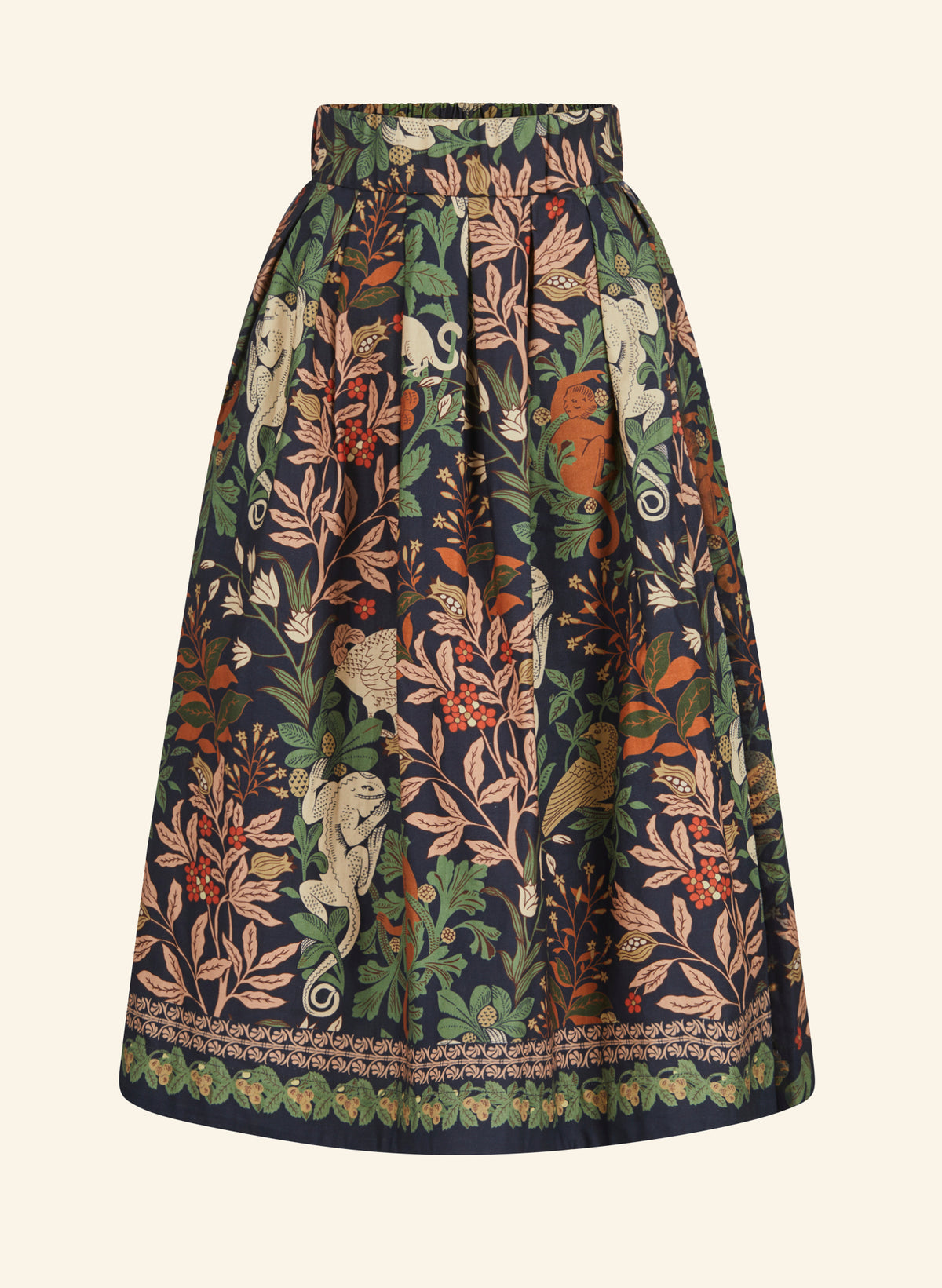 A high-waisted, pleated A-line skirt featuring an intricate botanical and animal print on a dark navy base. The pattern includes green leaves, beige birds, orange fruits, and cream-colored monkeys, finished with a decorative border along the hem.