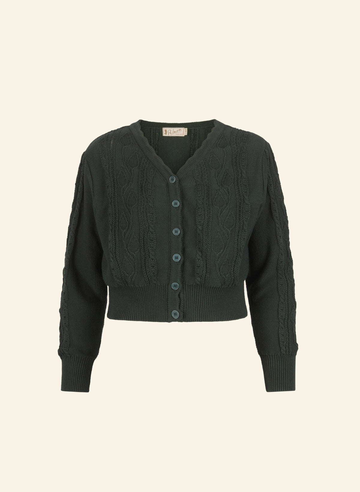 A dark forest green cropped cable-knit cardigan sweater with a V-neck, button-front closure, and ribbed cuffs and hem, shown against a solid cream background.