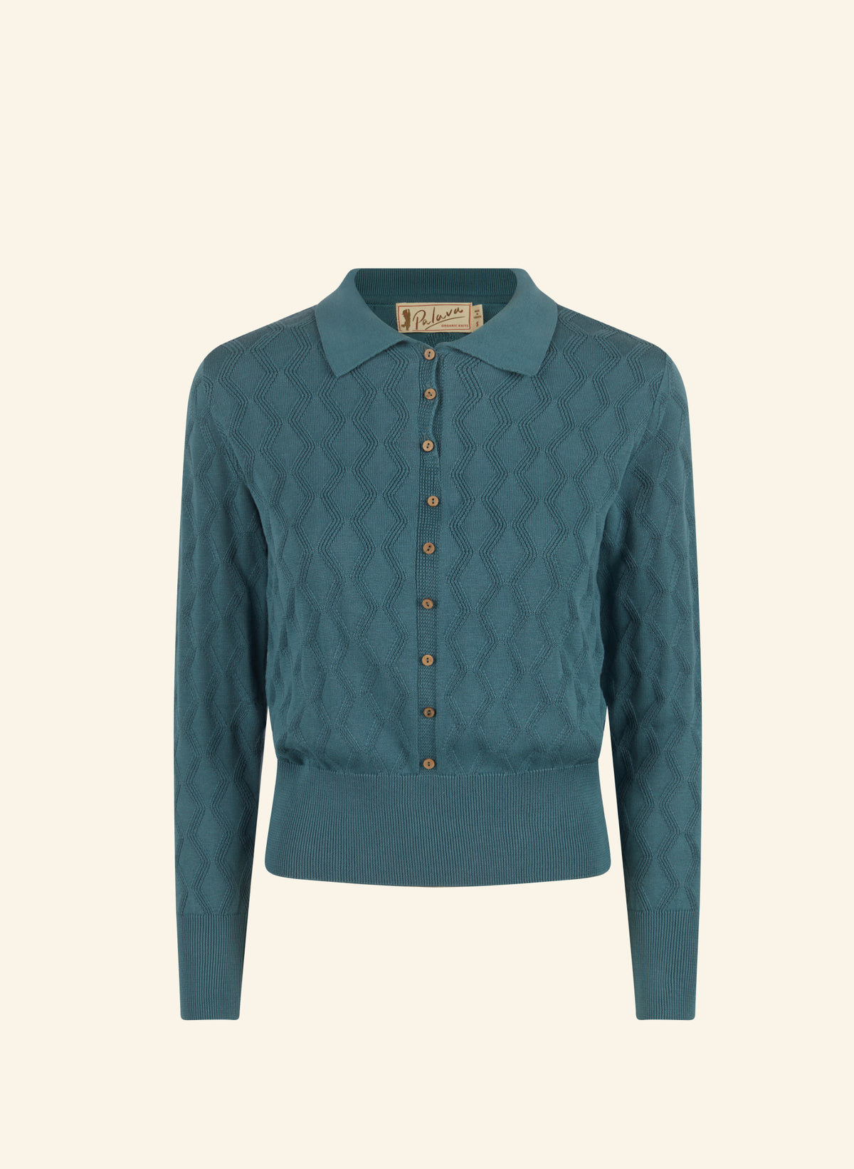 A teal blue-green knit polo cardigan with a diamond-quilted texture, button-front closure, and a pointed collar, shown on a solid cream background.